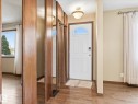 Front entry featuring a white door with an arched window, wood-finish flooring, and a semi-flush ceiling light fixture - 13504 116 St Nw, Edmonton, AB  - Indoor Photo Showing Other Room 