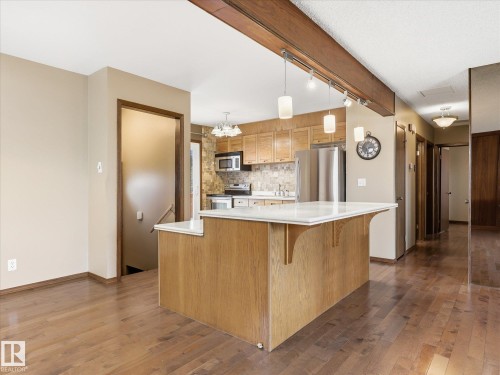 Kitchen island with a light-toned wood base and white countertop - 13504 116 St Nw, Edmonton, AB - Indoor Photo Showing Kitchen With Upgraded Kitchen