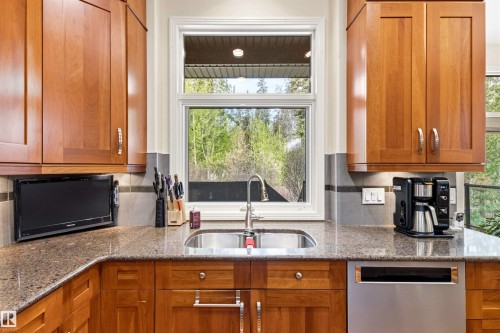 Kitchen workstation featuring a stainless steel undermount sink, a chrome faucet, and a large window - 1728 Rutherford Pt Point(E) Sw, Edmonton, AB - Indoor Photo Showing Kitchen With Double Sink