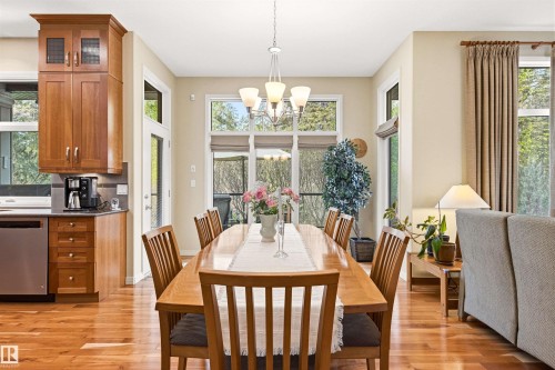 Dining area with wood-finish flooring and a multi-light chandelier - 1728 Rutherford Pt Point(E) Sw, Edmonton, AB - Indoor Photo Showing Dining Room