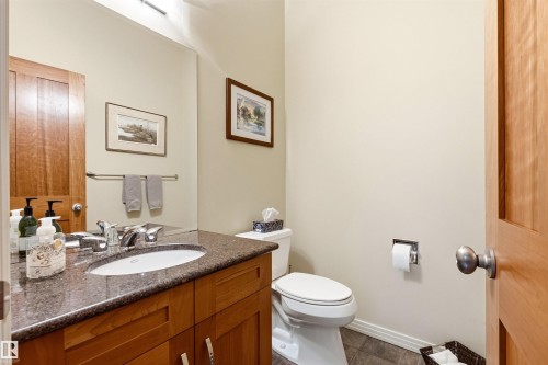 Bathroom featuring a wood vanity with a stone countertop and an undermount sink - 1728 Rutherford Pt Point(E) Sw, Edmonton, AB - Indoor Photo Showing Bathroom