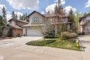 Stone facade residence featuring a double attached garage, concrete driveway, and mature landscaping - 1728 Rutherford Pt Point(E) Sw, Edmonton, AB  - Outdoor With Facade 