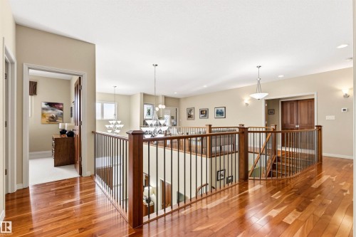Upper-level landing featuring wood-finish flooring, a wood and wrought iron railing system, neutral wall tones, and recessed lighting - 1728 Rutherford Pt Point(E) Sw, Edmonton, AB - Indoor Photo Showing Other Room
