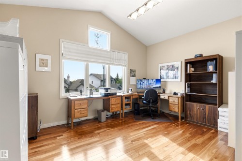 Vaulted ceiling room featuring large windows, wood-finish flooring, and a modern rectangular light fixture - 1728 Rutherford Pt Point(E) Sw, Edmonton, AB - Indoor Photo Showing Office
