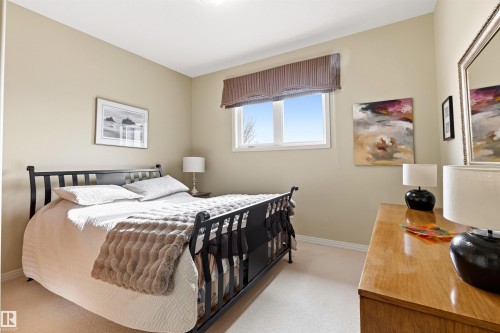 Bedroom featuring light neutral wall paint, a single window with a Roman shade, light-colored carpet flooring, and white baseboards - 1728 Rutherford Pt Point(E) Sw, Edmonton, AB - Indoor Photo Showing Bedroom