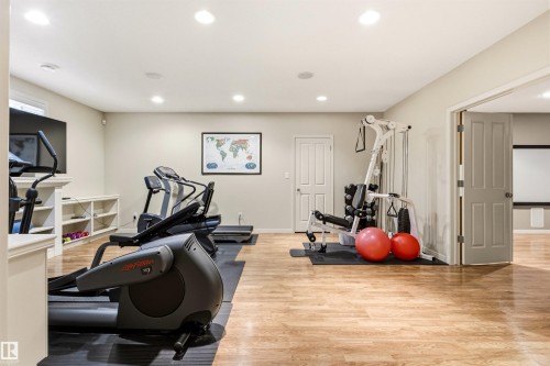 Spacious room featuring wood-finish flooring, recessed lighting, and neutral wall tones - 1728 Rutherford Pt Point(E) Sw, Edmonton, AB - Indoor Photo Showing Gym Room