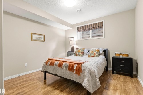 Bedroom featuring wood-finish flooring, a contemporary window with blind, and a ceiling-mounted light fixture - 1728 Rutherford Pt Point(E) Sw, Edmonton, AB - Indoor Photo Showing Bedroom