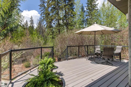 Spacious outdoor deck featuring composite decking, clear glass panel railings, and a built-in planter - 1728 Rutherford Pt Point(E) Sw, Edmonton, AB - Outdoor