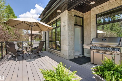 Spacious outdoor deck featuring composite decking, black railing, and a stone-clad exterior - 1728 Rutherford Pt Point(E) Sw, Edmonton, AB - Outdoor With Deck Patio Veranda With Exterior