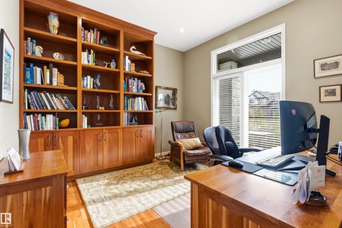 Expansive built-in wooden shelving with integrated lower cabinetry - 1728 Rutherford Pt Point(E) Sw, Edmonton, AB - Indoor Photo Showing Office
