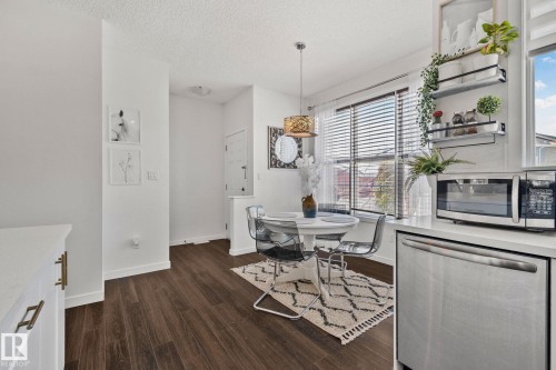 This bright space features dark wood-style flooring, white walls, and a window with blinds providing natural light - 336 Southfork Drive, Leduc, AB - Indoor Photo Showing Dining Room