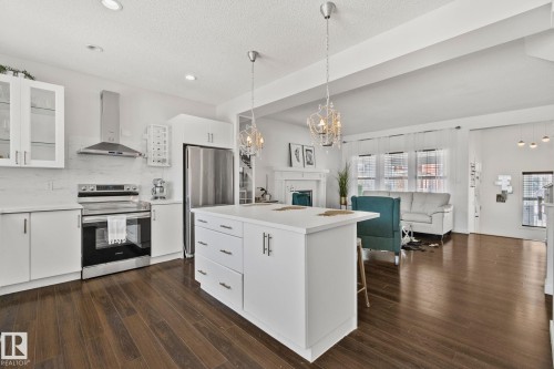 The property features an open-concept living space with dark hardwood floors throughout - 336 Southfork Drive, Leduc, AB - Indoor Photo Showing Kitchen With Upgraded Kitchen
