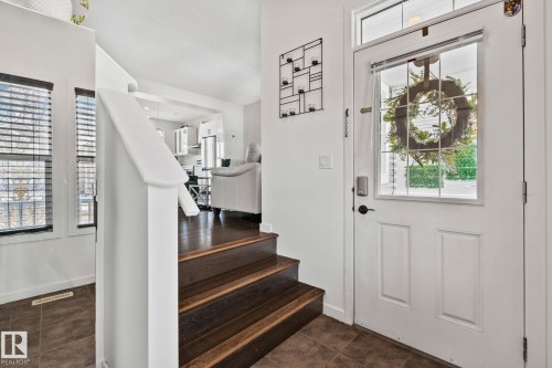 Entryway featuring a white paneled door with a transom window and glass inserts, dark wood steps, and tile flooring - 336 Southfork Drive, Leduc, AB - Indoor Photo Showing Other Room
