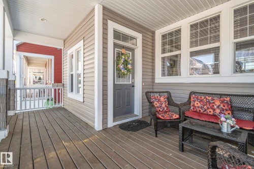 The property features a welcoming covered porch with wood flooring, siding, and a front entry door with a decorative wreath - 336 Southfork Drive, Leduc, AB - Outdoor With Deck Patio Veranda With Exterior