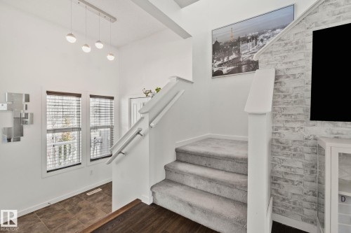 Entryway with a staircase featuring grey carpeted treads and white risers, leading to an upper landing - 336 Southfork Drive, Leduc, AB - Indoor Photo Showing Other Room