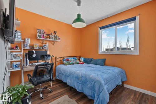 This room features hardwood style flooring and a window providing natural light - 336 Southfork Drive, Leduc, AB - Indoor Photo Showing Bedroom