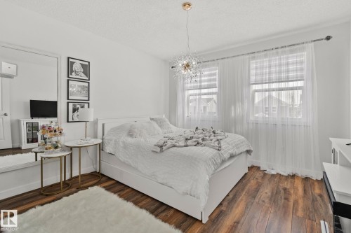 This inviting room features rich wood flooring and white walls, creating a bright and airy atmosphere - 336 Southfork Drive, Leduc, AB - Indoor Photo Showing Bedroom
