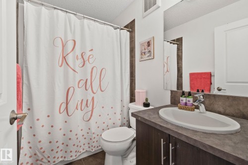 The bathroom features a vanity with a countertop and an integrated sink, a toilet, and a tiled shower area - 336 Southfork Drive, Leduc, AB - Indoor Photo Showing Bathroom