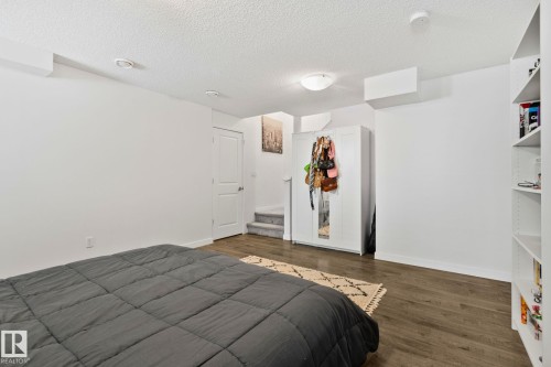 The room features hardwood flooring, white walls, and built-in shelving - 336 Southfork Drive, Leduc, AB - Indoor Photo Showing Bedroom