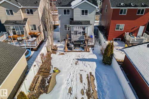 The property features an extensive backyard with a paved patio area, a deck, and raised garden beds - 336 Southfork Drive, Leduc, AB - Outdoor With Deck Patio Veranda