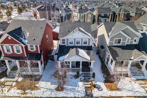 An aerial view showcasing three distinct properties, each featuring a front porch and traditional architectural details - 336 Southfork Drive, Leduc, AB - Outdoor With Deck Patio Veranda With Facade