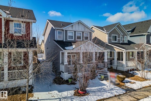 This property features a two-story design with a covered front porch, light gray siding, and white trim details - 336 Southfork Drive, Leduc, AB - Outdoor With Deck Patio Veranda With Facade