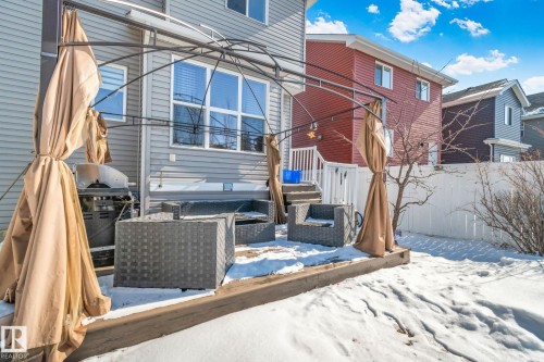 The property features a patio area with an overhead canopy structure and outdoor seating, leading to a fenced yard - 336 Southfork Drive, Leduc, AB - Outdoor With Exterior