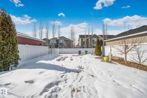 The property features a fenced yard with a partially paved surface and mature trees - 336 Southfork Drive, Leduc, AB - Outdoor