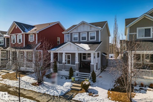 The property features a charming front porch with white railing, a welcoming front door, and a partially snow-covered lawn - 336 Southfork Drive, Leduc, AB - Outdoor With Deck Patio Veranda With Facade