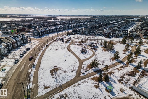 This aerial view highlights the neighborhood's expansive common green space, complete with paved walking paths and a play structure - 336 Southfork Drive, Leduc, AB - Outdoor With View