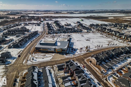 Aerial view highlighting the property's location within a residential area featuring numerous residential buildings, paved streets, and open spaces - 336 Southfork Drive, Leduc, AB - Outdoor With View