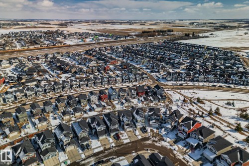Aerial view of a residential neighbourhood featuring numerous detached properties with varying exterior finishes and rooflines, surrounded by open, snow-covered fields - 336 Southfork Drive, Leduc, AB - Outdoor With View