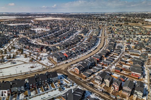 Aerial view showcasing a residential community with a variety of properties, including detached homes and townhomes, featuring dark-colored roofs - 336 Southfork Drive, Leduc, AB - Outdoor With View
