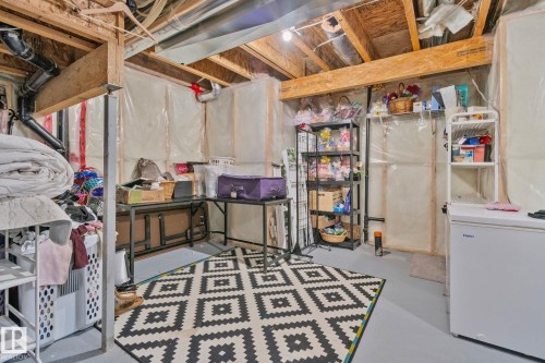 The property features an unfinished basement with exposed wooden beams, a partial concrete floor, and visible utility piping - 336 Southfork Drive, Leduc, AB - Indoor Photo Showing Basement