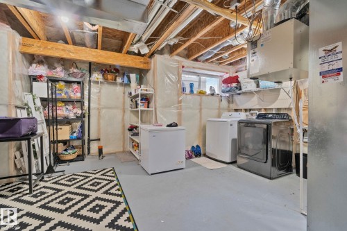 Laundry area featuring a window, painted concrete floor, and exposed ceiling joists - 336 Southfork Drive, Leduc, AB - Indoor Photo Showing Laundry Room