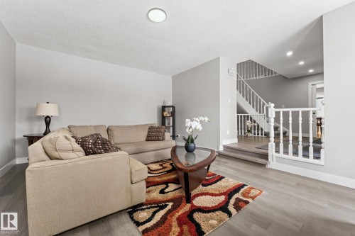 The property features light gray walls and dark flooring, with a staircase visible in the background - 10673 161 Avenue, Edmonton, AB - Indoor Photo Showing Living Room