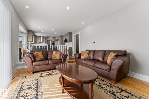 Living area featuring hardwood floors, recessed lighting, and a partial view of the kitchen with stainless steel appliances - 10673 161 Avenue, Edmonton, AB - Indoor Photo Showing Living Room