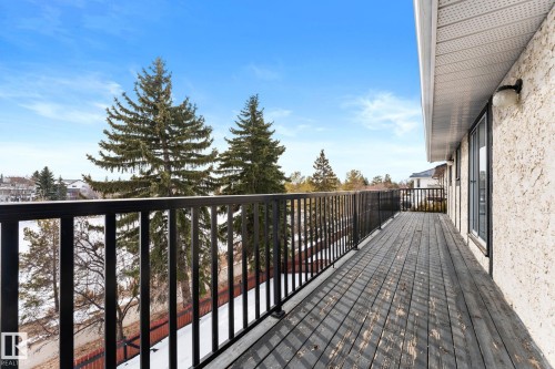 The property features an outdoor deck with a dark-stained wooden surface, enclosed by black metal railings - 10673 161 Avenue, Edmonton, AB - Outdoor With Balcony With Exterior