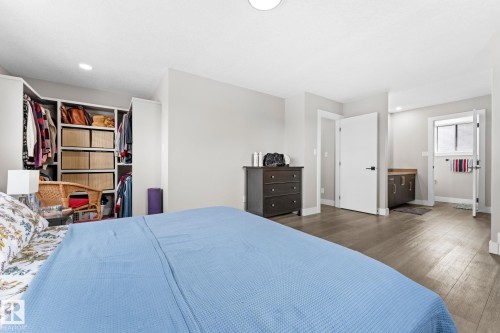 This room features hardwood-style flooring, recessed lighting, and a built-in open closet system with shelving and hanging space - 10673 161 Avenue, Edmonton, AB - Indoor Photo Showing Bedroom