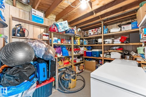 This utility space features exposed wood beams, shelving units, and a floor freezer - 10673 161 Avenue, Edmonton, AB - Indoor