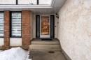 The property features a front entrance with concrete steps and a textured stucco exterior, complemented by brick detailing around the windows - 10673 161 Avenue, Edmonton, AB  - Outdoor 