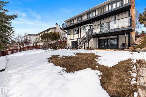 The property features a multi-level exterior with balconies, a staircase leading to the yard, and sliding glass doors - 10673 161 Avenue, Edmonton, AB - Outdoor