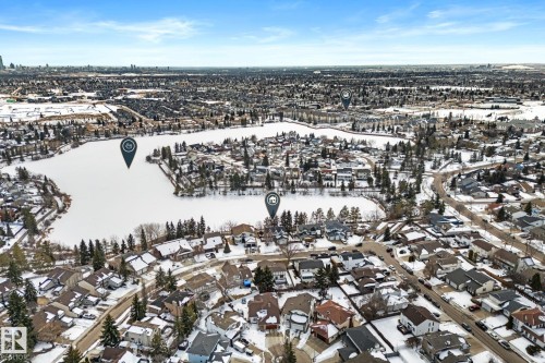 Aerial view showcasing the lake, surrounding residential properties, and distant city skyline - 10673 161 Avenue, Edmonton, AB - Outdoor With View