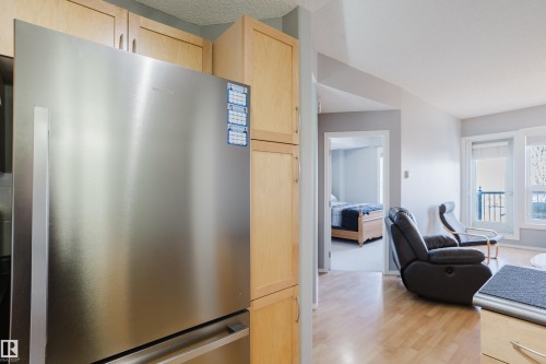 Stainless steel refrigerator integrated into light wood-finish cabinetry - 508 11103 84 Avenue, Edmonton, AB - Indoor