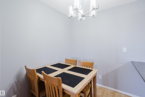 Recessed ceiling with a contemporary chandelier and light wood-finish flooring - 508 11103 84 Avenue, Edmonton, AB - Indoor Photo Showing Dining Room
