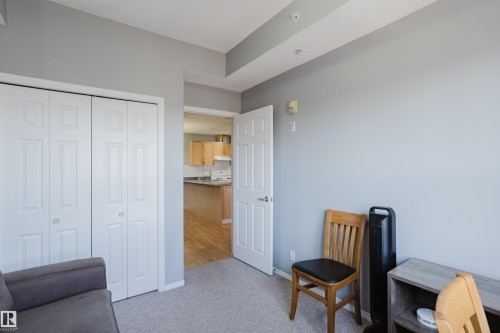 Room featuring neutral gray wall paint, light-colored carpet flooring, and white bi-fold closet doors - 508 11103 84 Avenue, Edmonton, AB - Indoor Photo Showing Bedroom