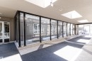 Entry corridor featuring a glass wall with black framing, skylights, tiled flooring, and dual entrance doors - 508 11103 84 Avenue, Edmonton, AB  - Indoor Photo Showing Other Room 