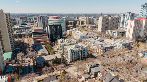 Urban landscape featuring a mix of residential and commercial buildings, diverse architectural styles, high-rise structures, and tree-lined streets - 508 11103 84 Avenue, Edmonton, AB - Outdoor With View