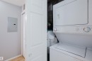 Dedicated laundry closet featuring a white stacked washer and dryer unit, a water heater, and light wood-finish flooring - 508 11103 84 Avenue, Edmonton, AB  - Indoor Photo Showing Laundry Room 