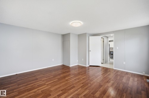Open room featuring wood-finish flooring, light gray wall paint, and white trim - 106 Springfield Crescent, Spruce Grove, AB - Indoor Photo Showing Other Room